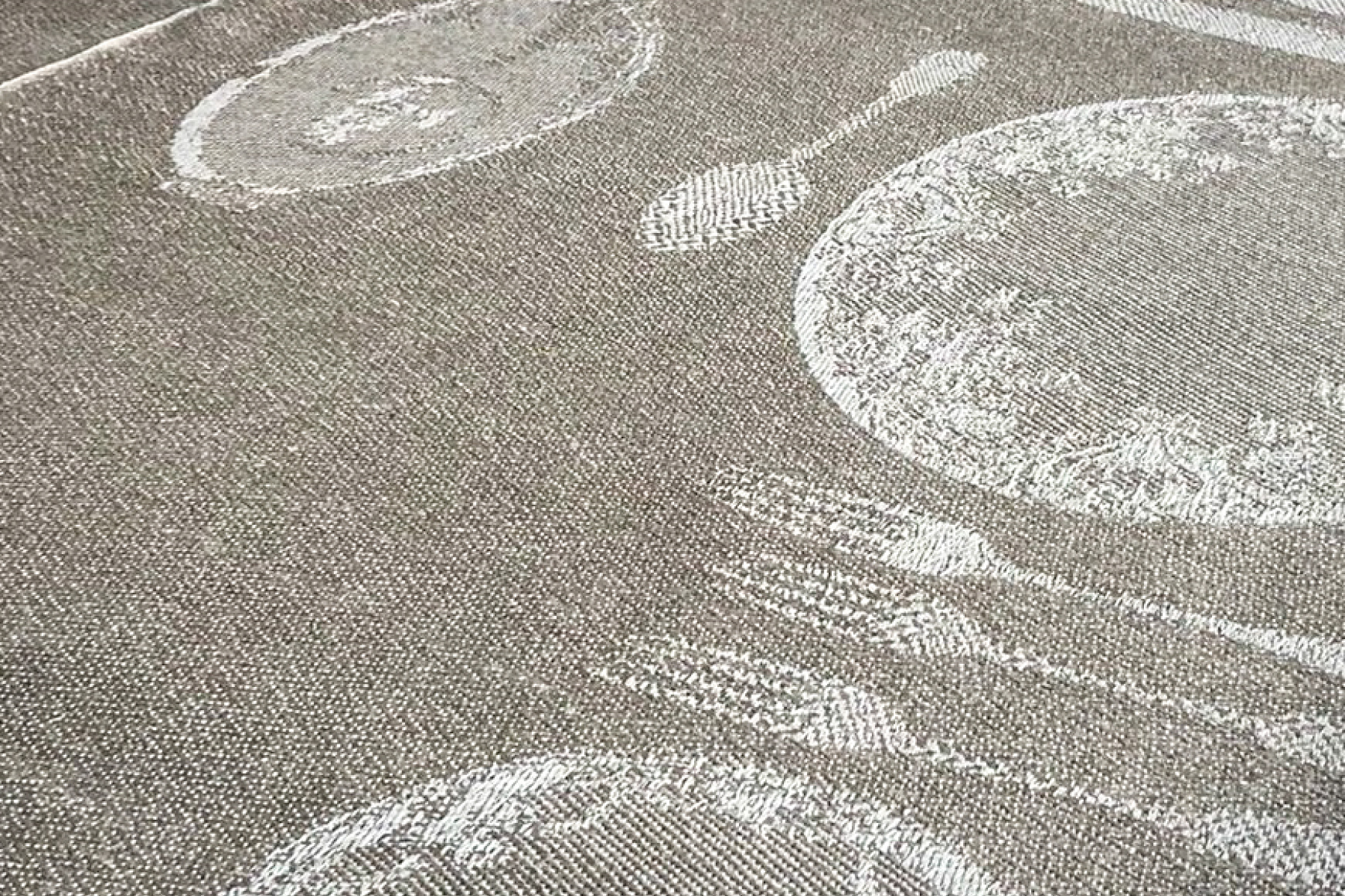 <p>Deltaljbilde av en duk med innvevd bestikk og tallerken</p>